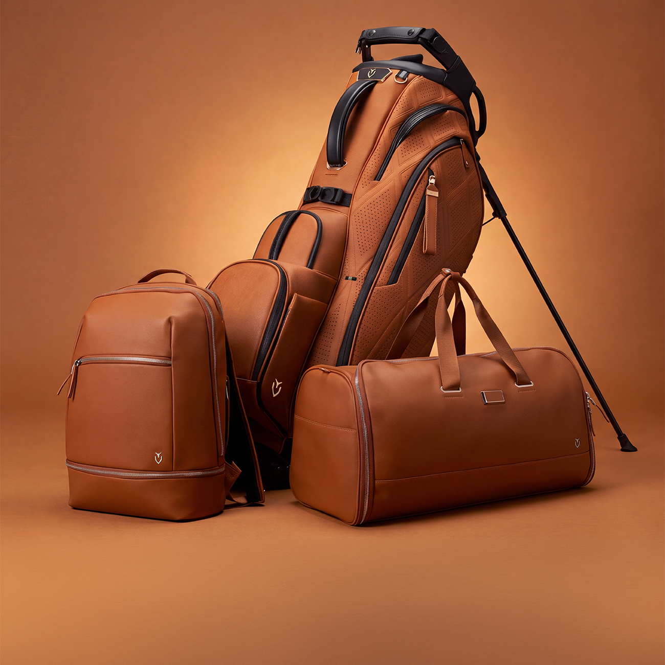 Heritage brown player v pro bag, signature backpack, and garment duffel on brown background