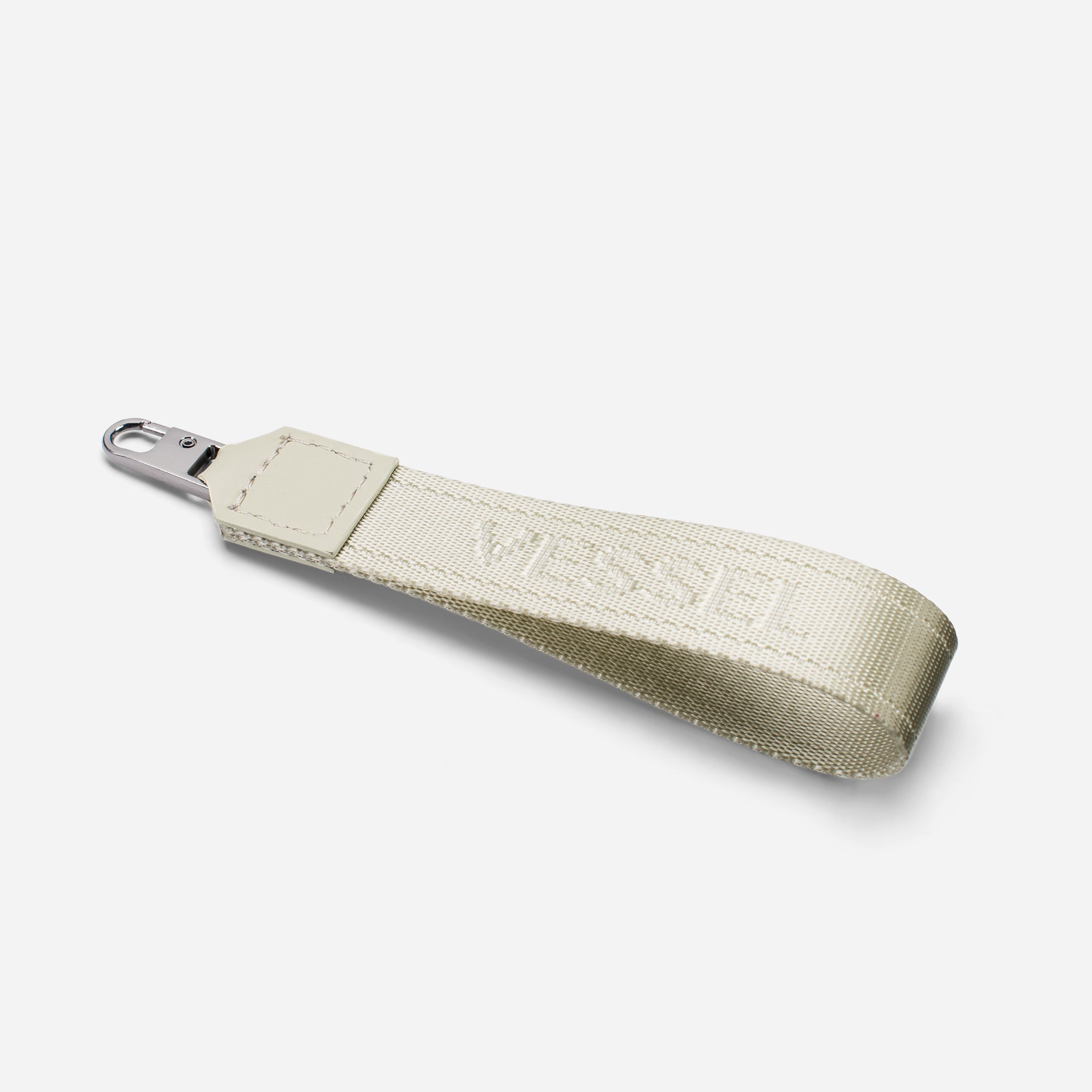 White jacquard fabric loop zipper pull against a white background at an angle