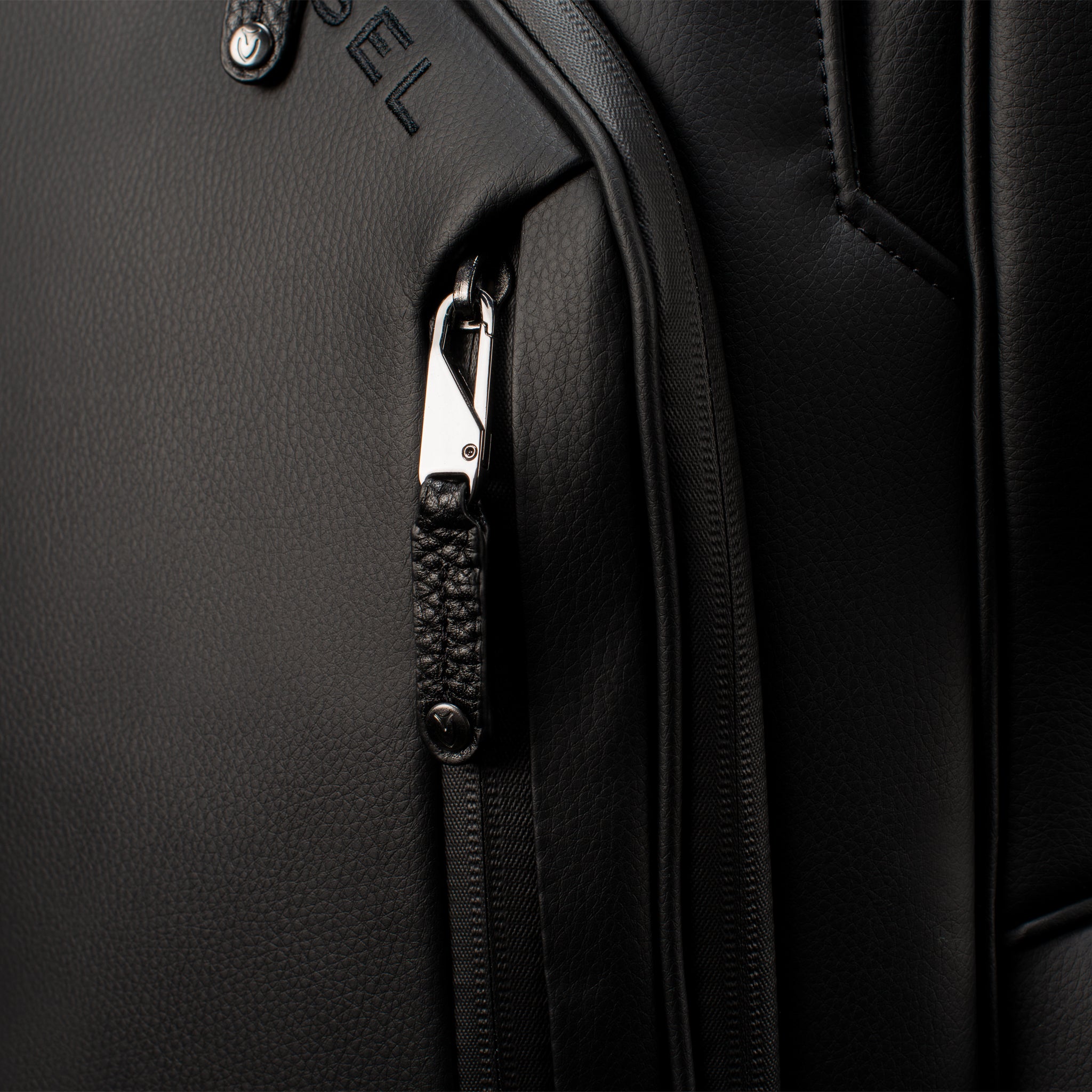 Close up of personal pocket zipper on black leather golf cart bag