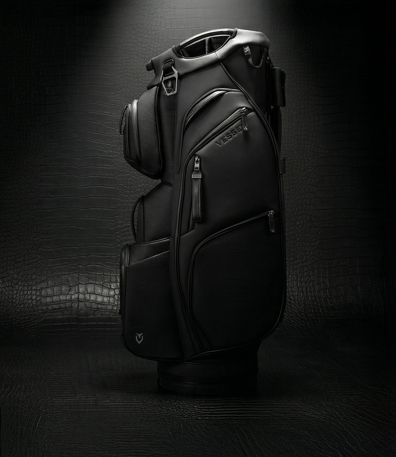 Black leather golf bag against a crocodile leather background