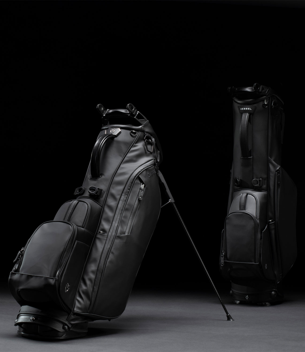 Three black golf stand bags in a black studio