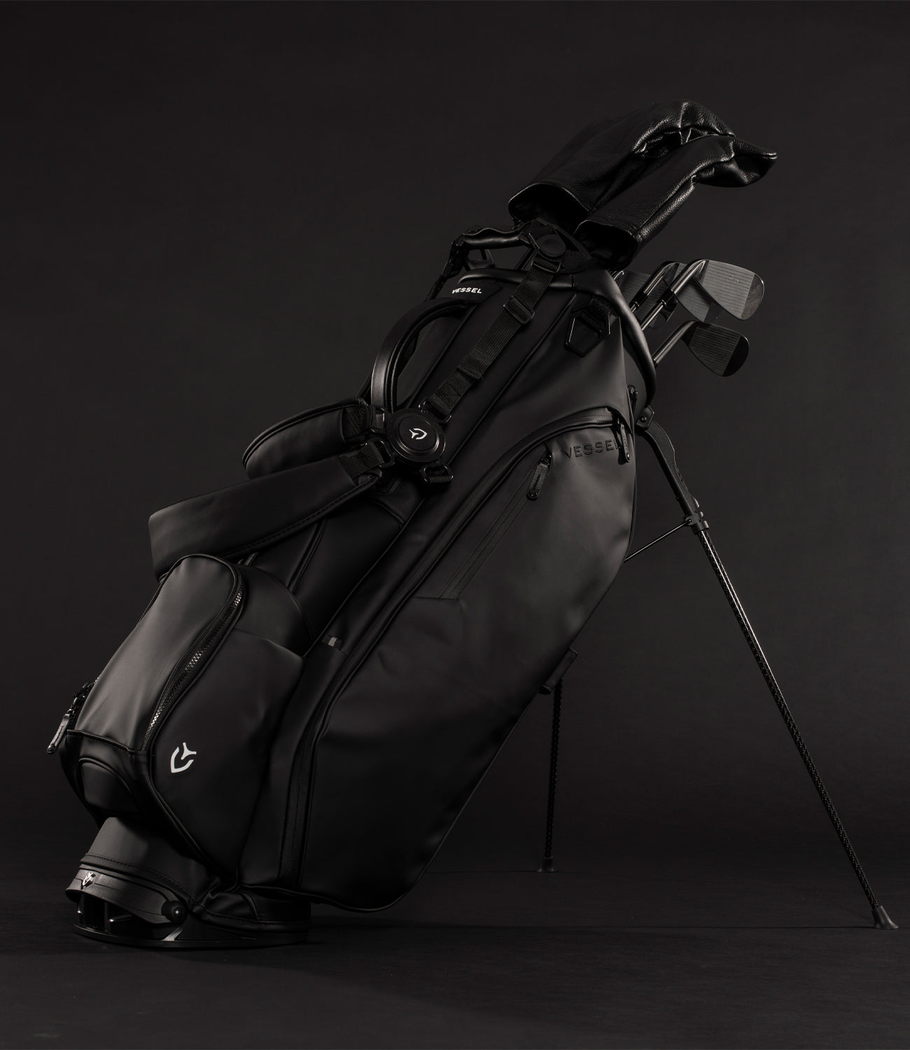 Black golf stand bag with golf clubs with headcovers in black studio