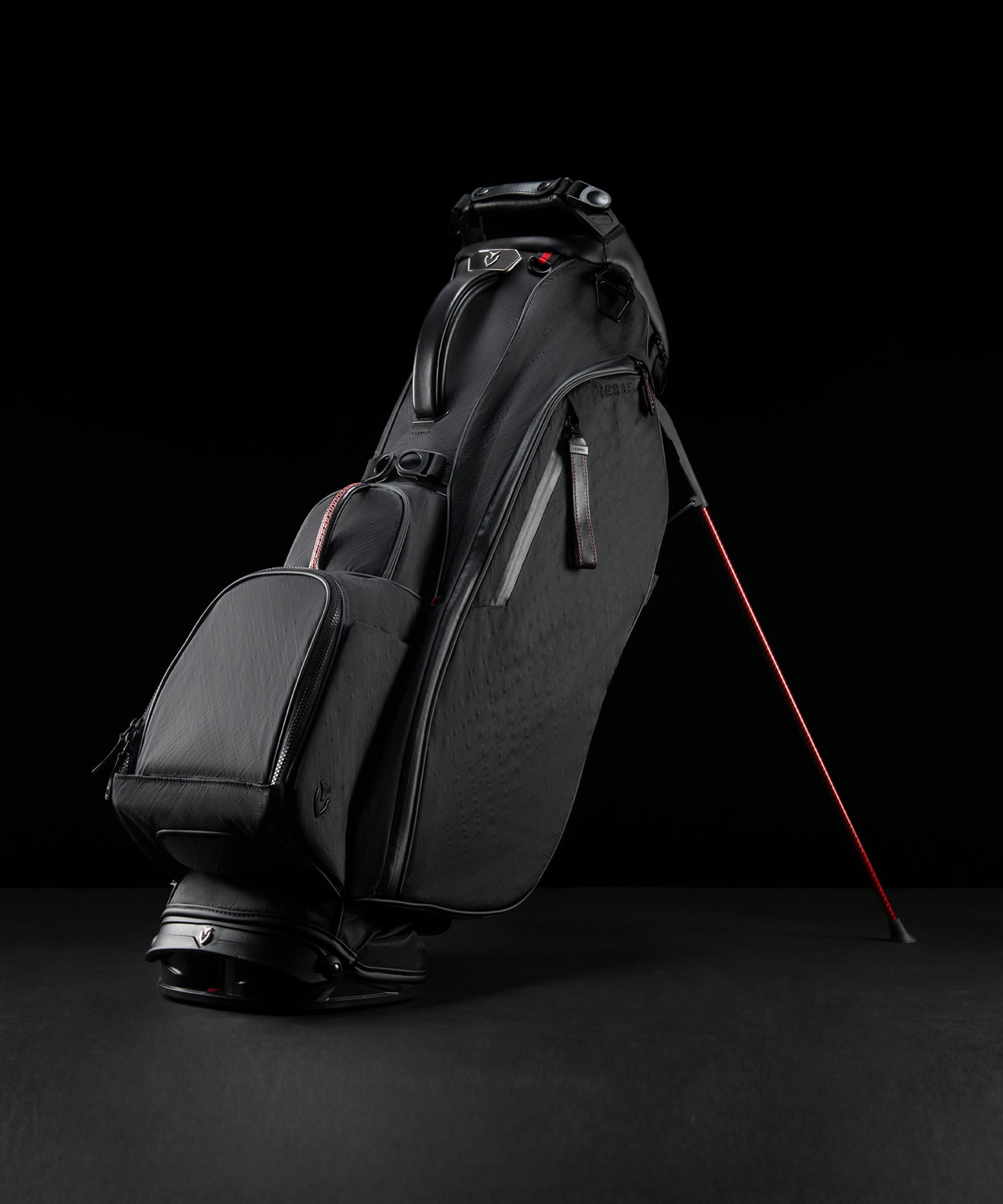 Black lightweight golf bag with red accents on a black background