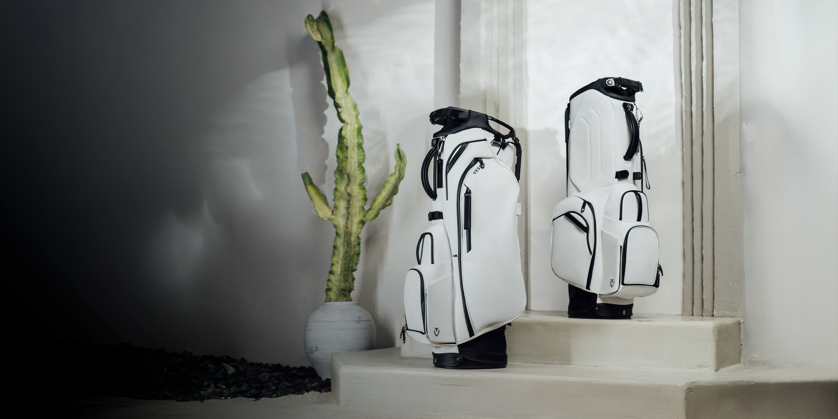 Two white golf bags set on stone steps