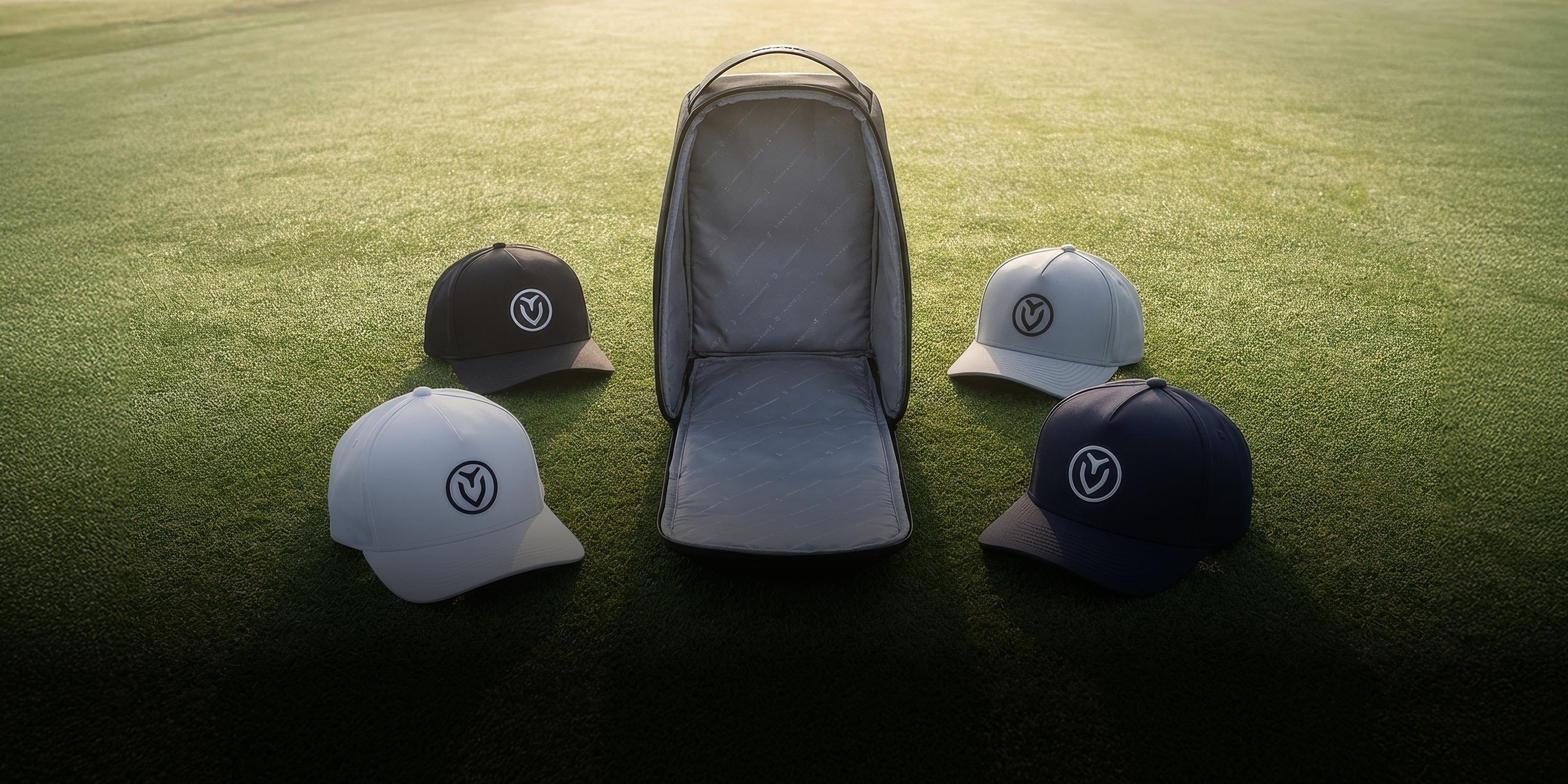 Voyager Headwear bag with four Vessel hats in grass field