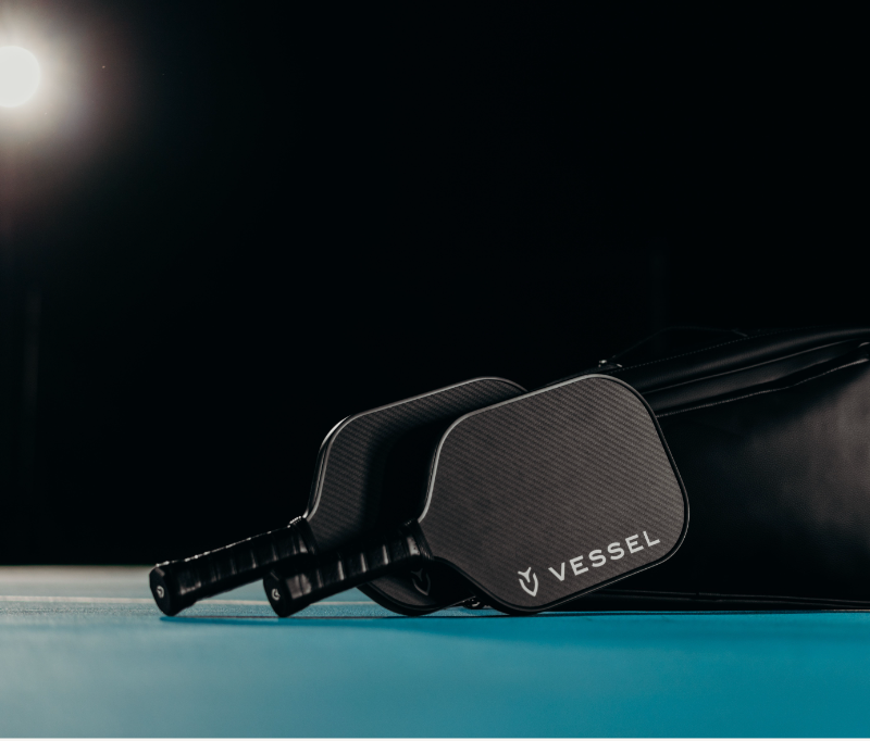 Pickleball paddles next to black pickleball bag