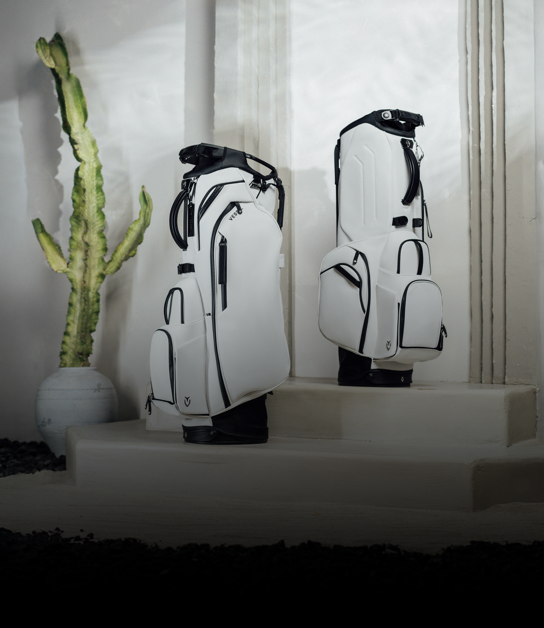 Two white golf bags set on stone steps