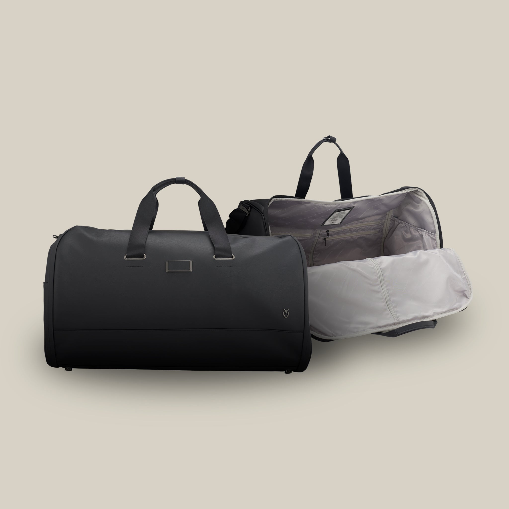 Two black leather duffel bags on a taupe background.