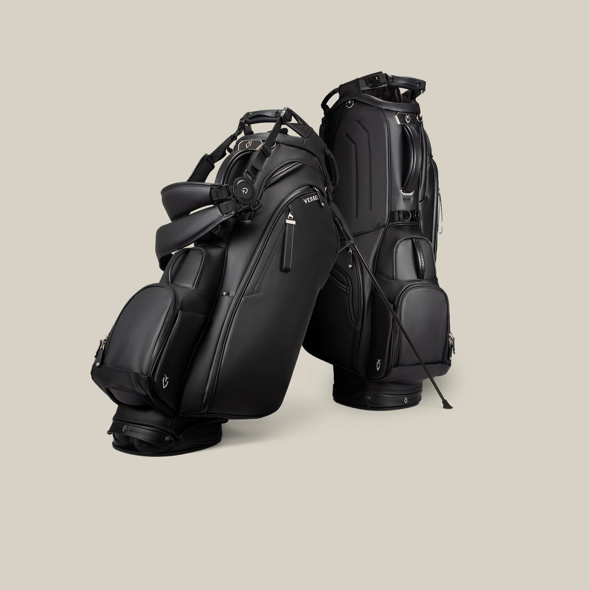 Two black golf bags on a taupe background. 