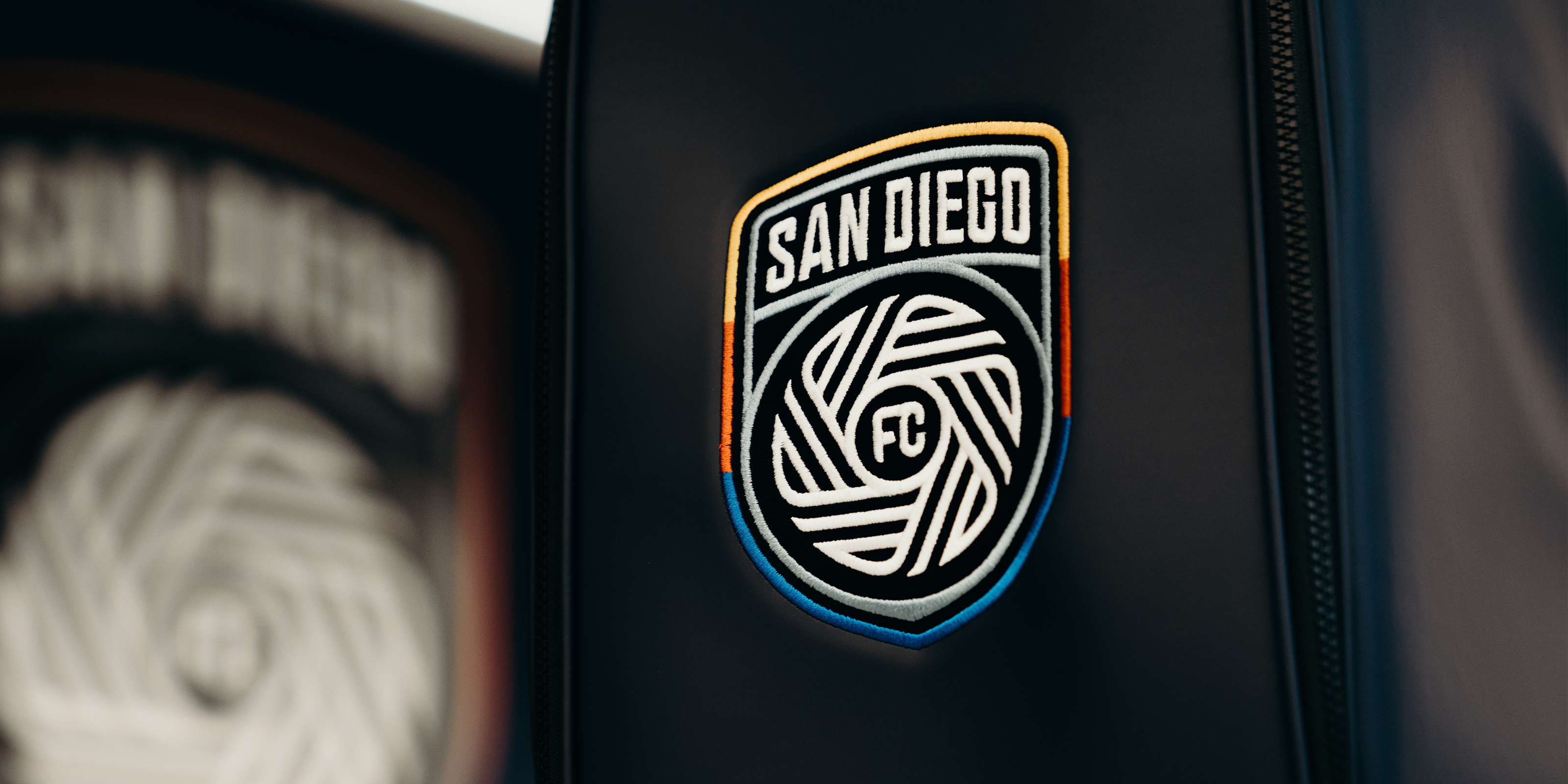 Close up image of a navy prime 2.0 staff bag with the San Diego FC Logo embroidered on the front.